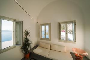 a living room with a couch and three windows at Santonero in Akrotiri