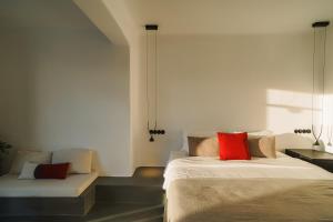 a bedroom with a bed with red pillows and a couch at Santonero in Akrotiri