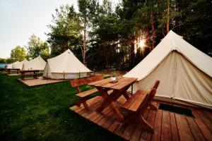 a group of tents with tables and benches on a deck at Czyli Chill in Nisko