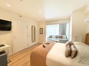 a bedroom with a large white bed and a couch at Hôtel de Provence in Cannes