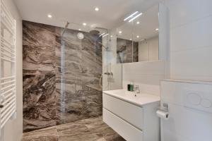 a white bathroom with a shower and a sink at De Kleine Lantaarn in Bergen op Zoom +28 photos
