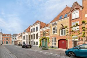 a street with buildings and cars parked on the street at De Kleine Lantaarn in Bergen op Zoom