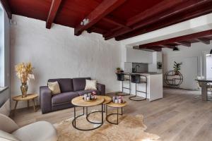 a living room with a couch and a table at De Kleine Lantaarn in Bergen op Zoom