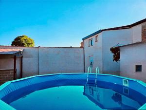 a blue swimming pool in front of a building at Morada del Santo in Fontiveros