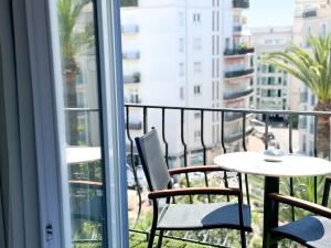 a balcony with a table and chairs and a table at Hôtel de Provence in Cannes