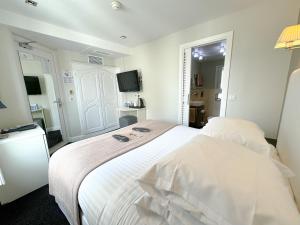 a hotel room with two beds and a television at Hôtel de Provence in Cannes