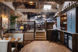 a man standing at a bar in a restaurant at Pier House in St Austell