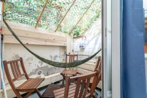 two chairs and a hammock on a porch at Repaire Des Pirates Sainte Marie in Sainte-Marie-la-Mer