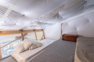 a bed in a room with a white ceiling at Repaire Des Pirates Sainte Marie in Sainte-Marie-la-Mer