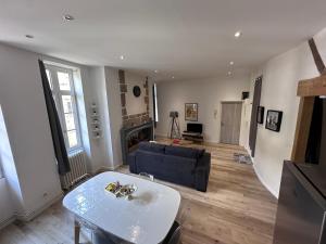 a living room with a couch and a table at Bel appartement en coeur de ville - 20 minutes du PAL in Moulins