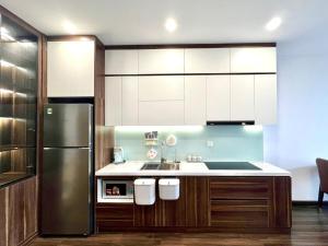a kitchen with white cabinets and a stainless steel refrigerator at LeeVy Hai Phong in Hai Phong