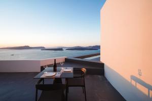 a table and chairs on a balcony with a view at Santonero in Akrotiri