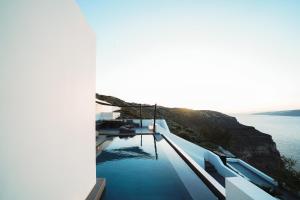 a swimming pool on the side of a house overlooking the water at Santonero in Akrotiri