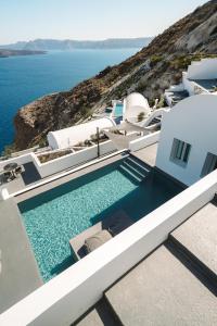 a swimming pool on the side of a house with the ocean at Santonero in Akrotiri