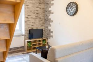 ein Wohnzimmer mit Sofa und Fernseher in der Unterkunft T2 Contemporain idéalement situé in Briançon