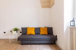 a couch with two yellow pillows in a room at Al Duomo in Brindisi