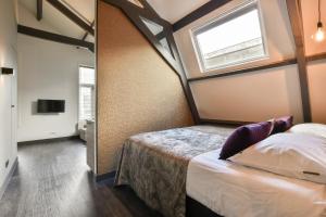 a bedroom with a bed and a window at Loft Studio's in Zandvoort
