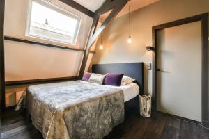 a bedroom with a bed and a window at Loft Studio's in Zandvoort