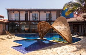 a pool with a sculpture in front of a building at Toya Hotel in Ilha Comprida