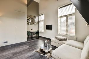 a living room with a couch and a table at Loft Studio's in Zandvoort