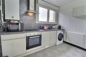 eine Küche mit einer Spüle, einem Herd und einem Geschirrspüler in der Unterkunft Le Payen - 3 chb Confort - balcon - Mon Groom in Troyes