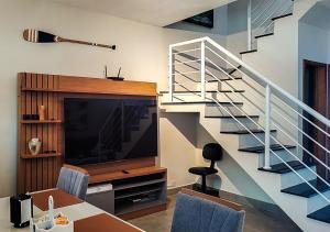 een woonkamer met een eettafel en een trap bij Serena Beach Triplex in Caraguatatuba