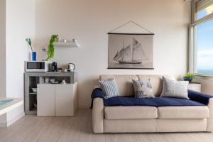 a living room with a couch and a picture of a boat at Nel blu dipinto di blu in Villa Solari +31 photos