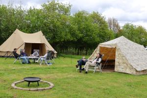 a group of people sitting in chairs in front of a tent at Tent-Ok Westerbeek in Westerbeek