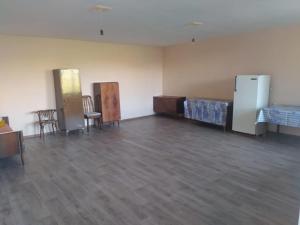 an empty room with beds and tables and chairs at 2 Floor House with big garden and Mountain View in Bjni in Bjni