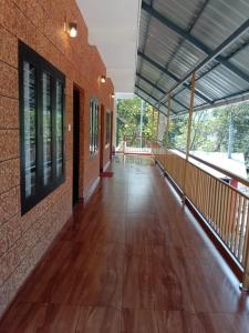 an empty hallway of a brick building with a hard wood floor at Athirappilly Inn Rooms & Suites in Athirappilly +7 photos