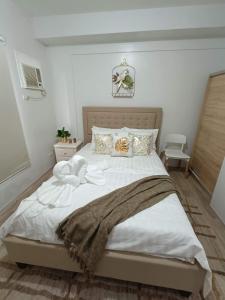 a bedroom with a large bed with white sheets and pillows at Minimalist Condo Studio at Messavire Garden Residence near Ruins Bacolod in Bacolod