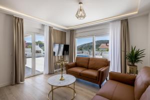 ein Wohnzimmer mit Sofa und Tisch in der Unterkunft Villa Sea View - heated pool & 2 mins to the beach in Vinišće