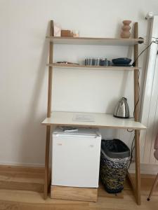 a desk with a refrigerator under a shelf at Casa Dora in Bern
