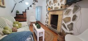 Una sala de estar con chimenea y un sofá. en Casa del Castillo, en Cazorla