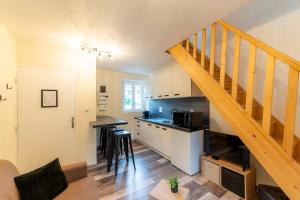 eine Küche und ein Wohnzimmer mit einer Treppe in der Unterkunft T2 Cosy idéalement situé in Briançon