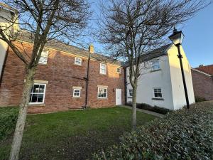 a large brick building with trees in front of it at The Puffin Pad - Part of the The Bay Filey Holiday Village with pool, gym and direct beach access, pub, restaurant, tennis and meadows walks in Filey