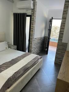a bedroom with a bed and a large window at Ilio Boutique Hotel in Ksamil