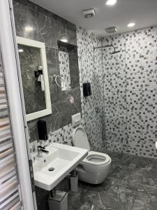 a bathroom with a toilet and a sink at Ilio Boutique Hotel in Ksamil