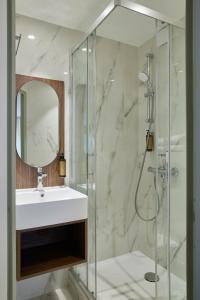 a bathroom with a sink and a shower at Hotel du Pin Nice Port by Soniho in Nice