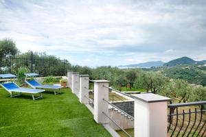 ラヴァーニャにあるVilla Angelinaの芝生の上に青い椅子が置かれたバルコニー