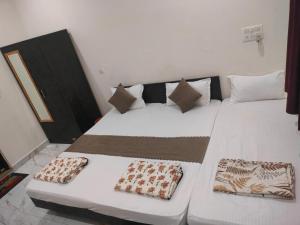 a large white bed with two pillows on it at Hotel Dev Inn Ayodhya in Ayodhya