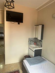 a bedroom with a bed and a sink and a tv at ESER PALAS OTELİ in Konya