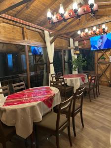 a dining room with tables and chairs and a tv at SAFI FOREST village in Dospat