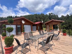 a deck with tables and chairs on a cabin at SAFI FOREST village in Dospat