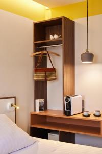 a room with a bed and a desk with a microwave at Hotel du Pin Nice Port in Nice