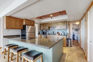 una cucina con un bancone e degli sgabelli di Village Round Dreams a Park City