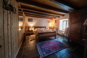 Un dormitorio con una cama y una alfombra en el suelo. en La ferme aux belles sources, en Dommartin-lès-Remiremont