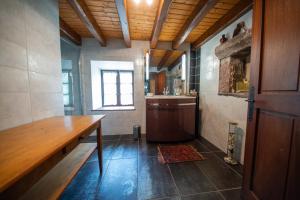 cocina con mesa de madera y ventana en La ferme aux belles sources, en Dommartin-lès-Remiremont