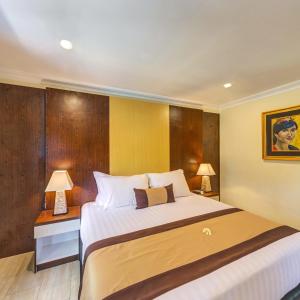 a bedroom with a large bed and two lamps at Vila Ombak in Gili Trawangan