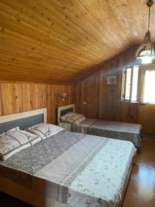 two beds in a room with wooden walls at Bjni Mer Dacha in Bjni +9 photos